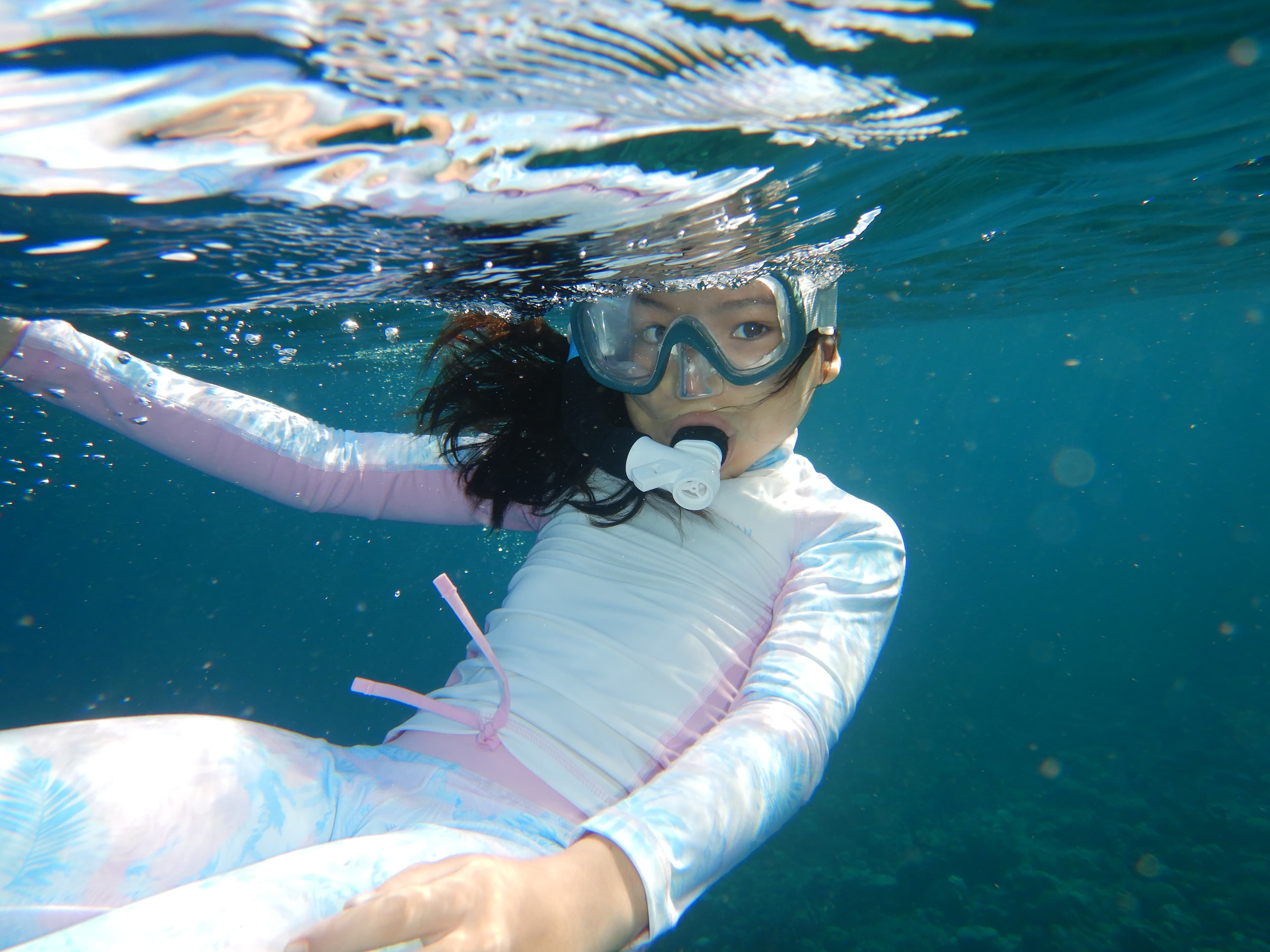Child snorkeling with mask near the surface