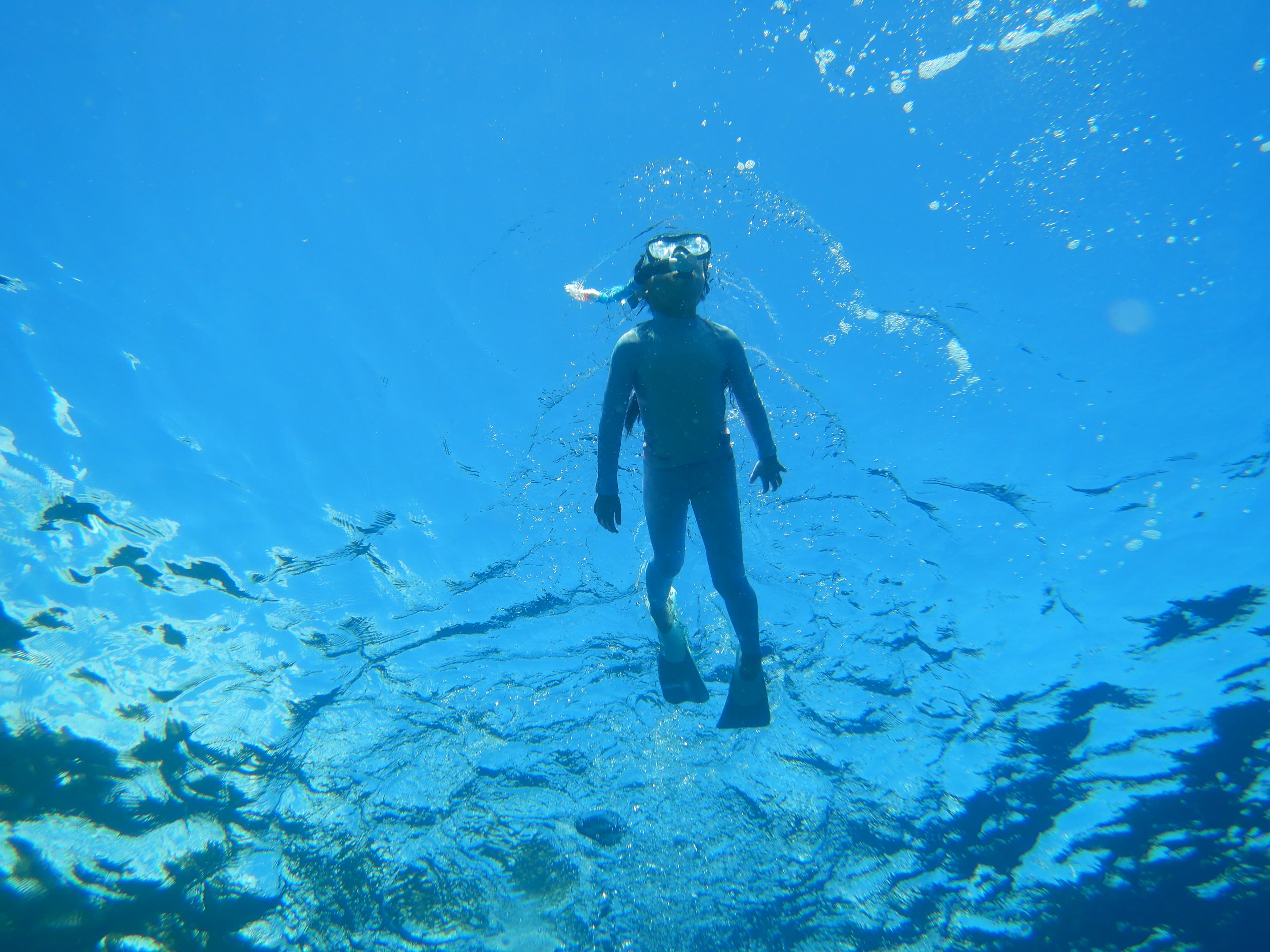Child freediving from below