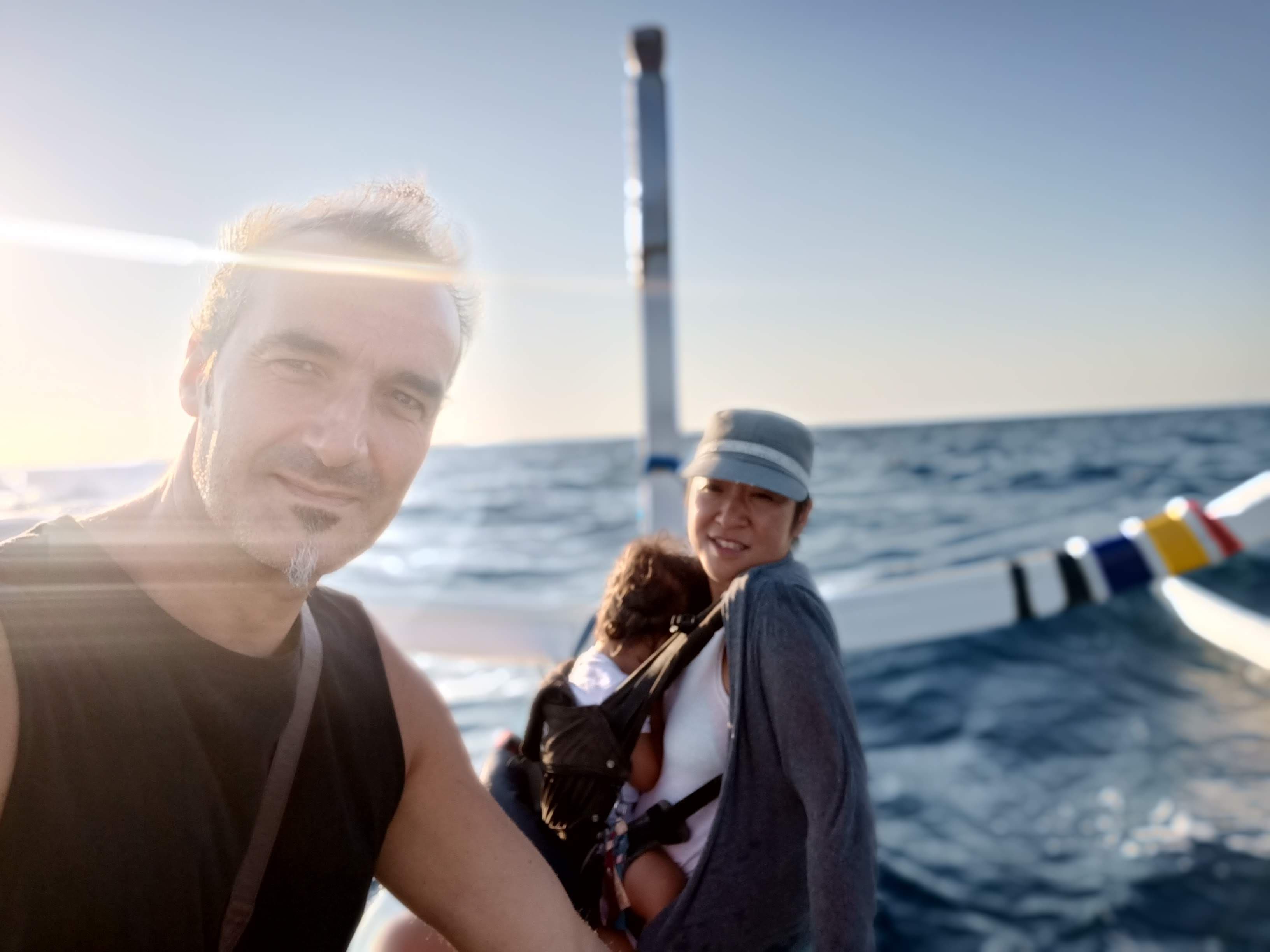 Family selfie on a boat at golden hour