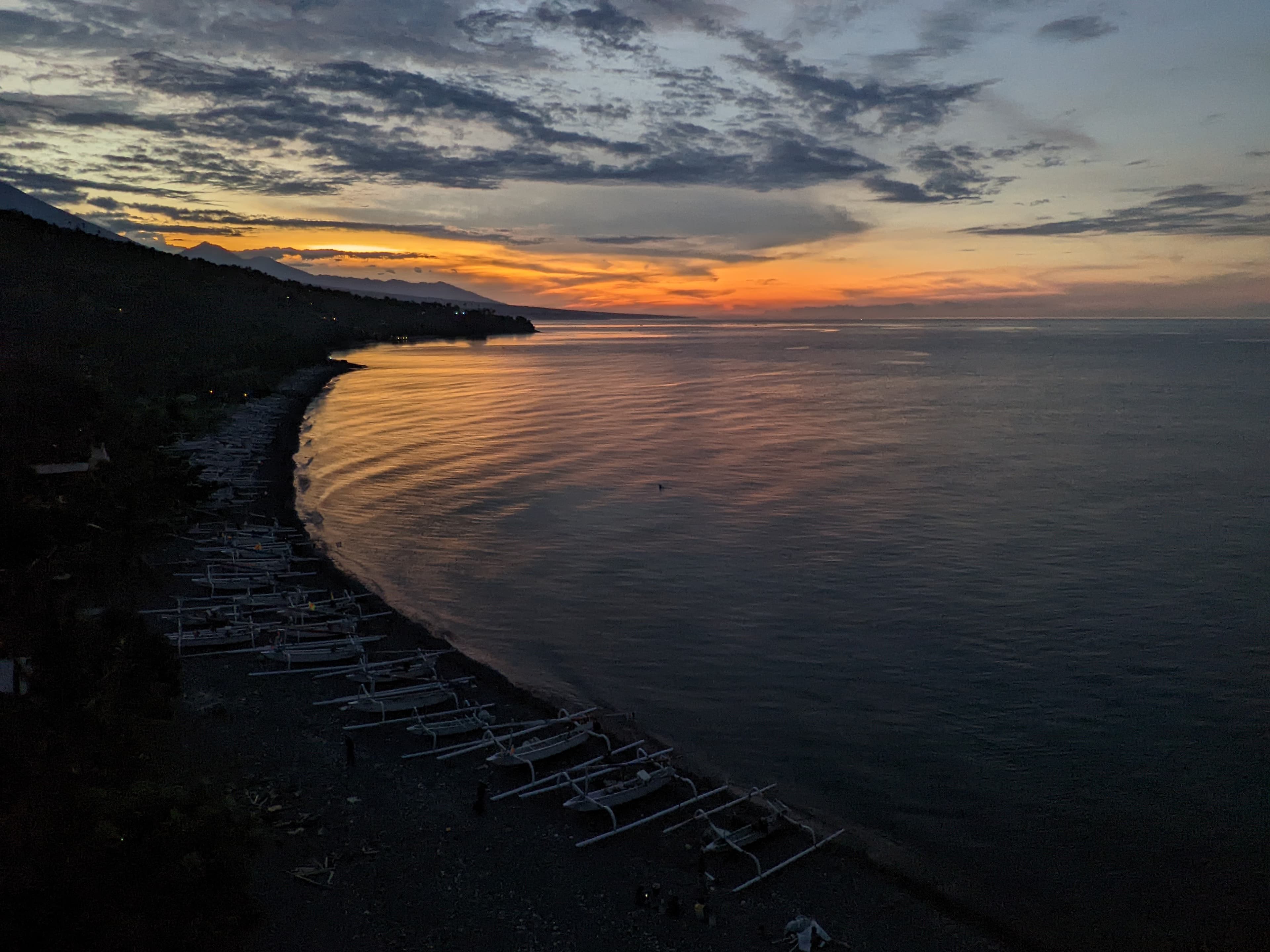 Sunset over a bay with traditional boats