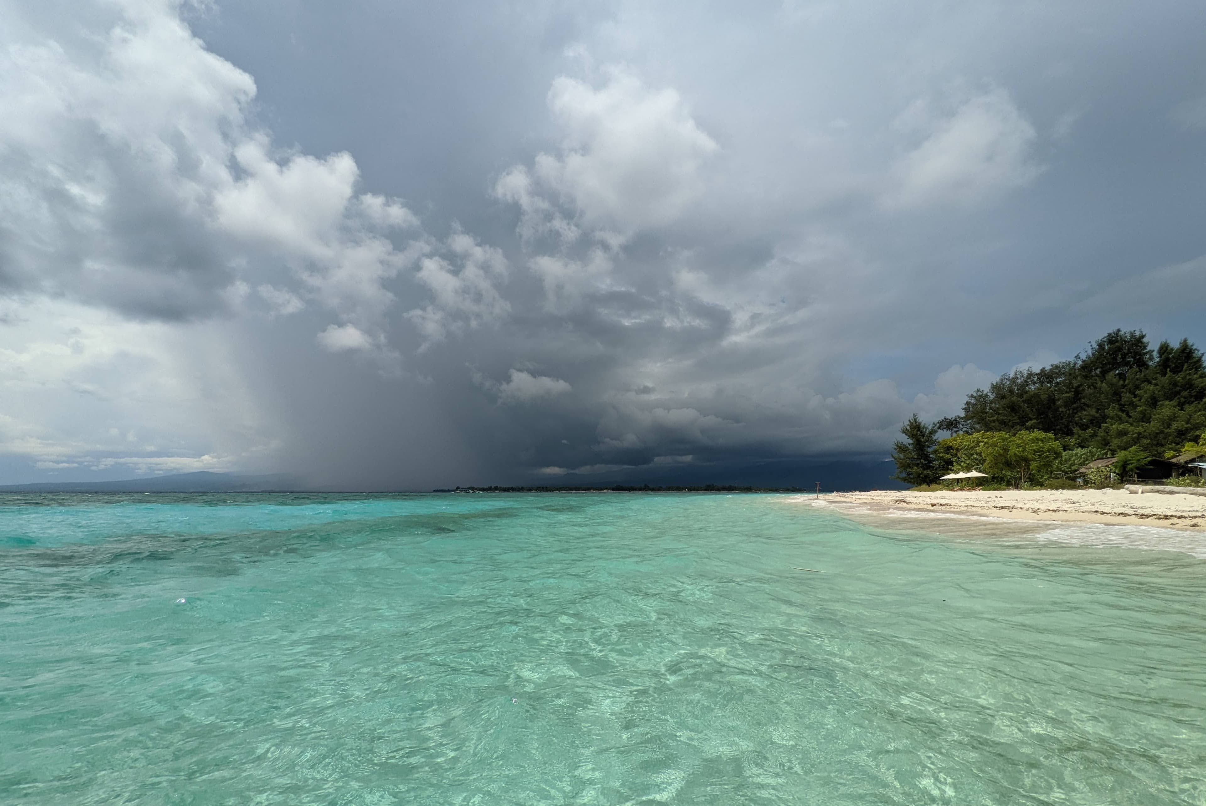 Storm rolling in over turquoise water and white sand